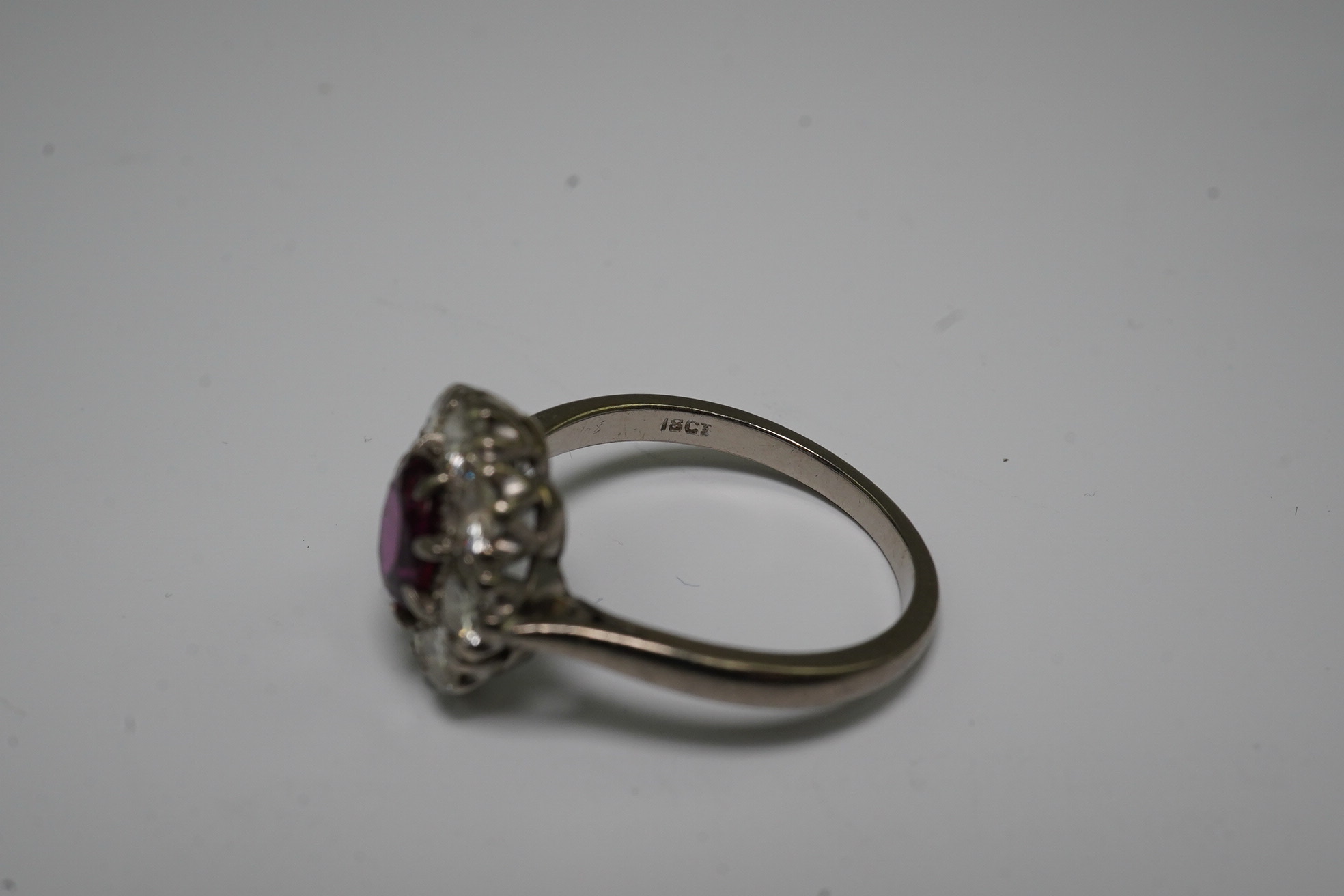 An 18ct white gold, ruby and diamond set oval cluster ring